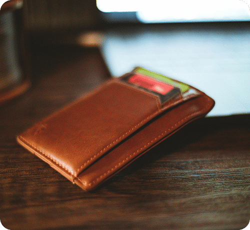 A brown leather wallet with a credit card in the front pocket